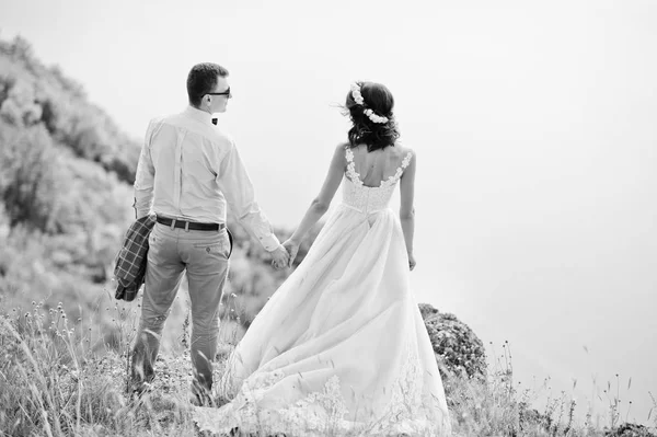 Fantástica pareja de boda de pie en el borde del precipicio rocoso —  Fotos de Stock