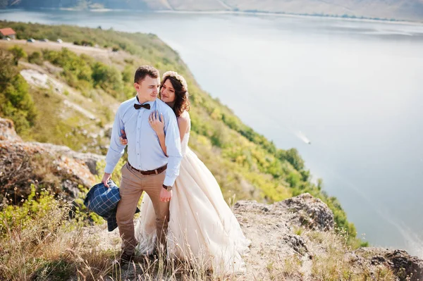 Casal de casamento fantástico em pé na borda do precipício rochoso — Fotografia de Stock