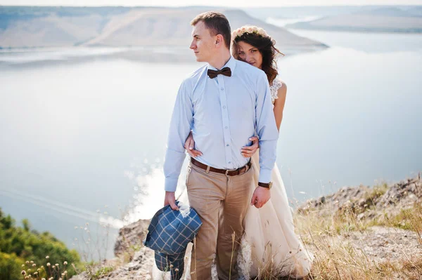Fantastic wedding couple standing on the edge of rocky precipice