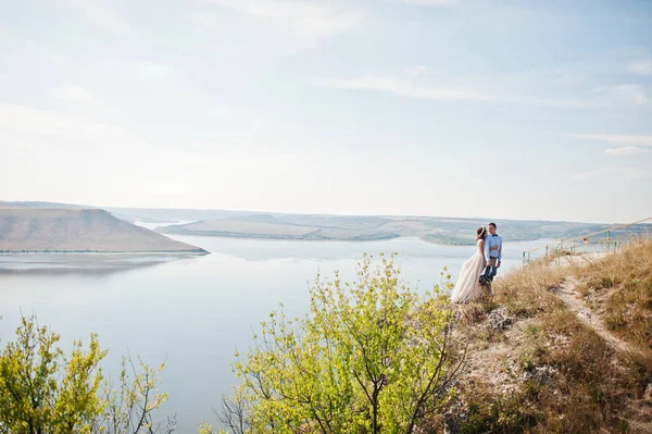 Fantastic wedding couple standing on the edge of rocky precipice