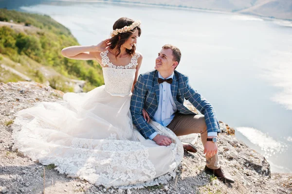 Superbe jeune couple de mariage assis sur le bord de la falaise w — Photo