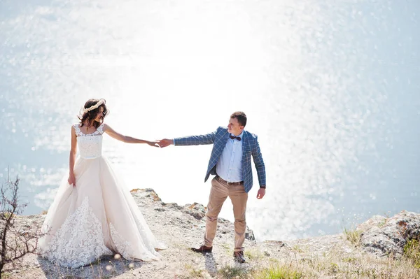 Fantástica pareja de boda de pie en el borde del precipicio rocoso —  Fotos de Stock