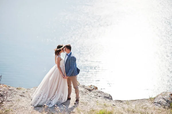 Fantástica pareja de boda de pie en el borde del precipicio rocoso —  Fotos de Stock
