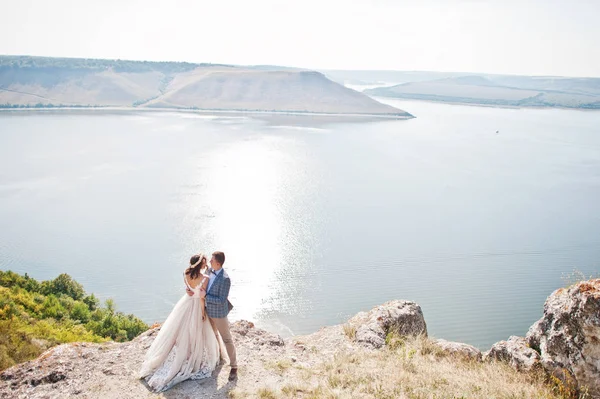 Fantástica pareja de boda de pie en el borde del precipicio rocoso — Foto de Stock