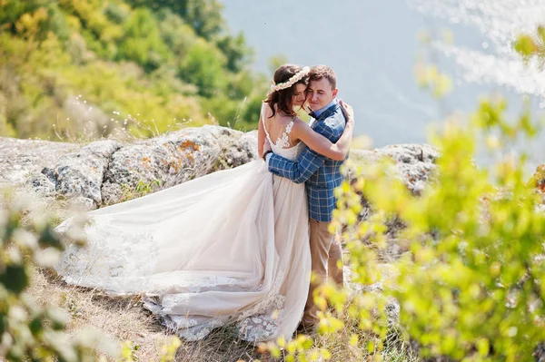 Fantastická svatební pár stojící na okraji skalnatého srázu — Stock fotografie