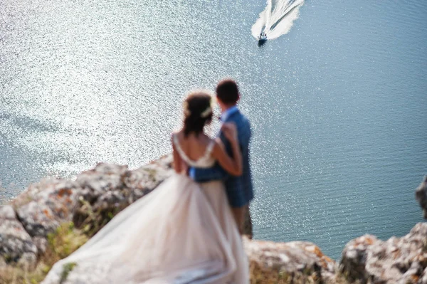 Awesome wedding couple admiring view of lake and boat sailing fr — Stock Photo, Image