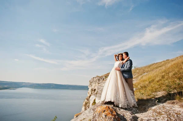 Fantástica pareja de boda de pie en el borde del precipicio rocoso — Foto de Stock