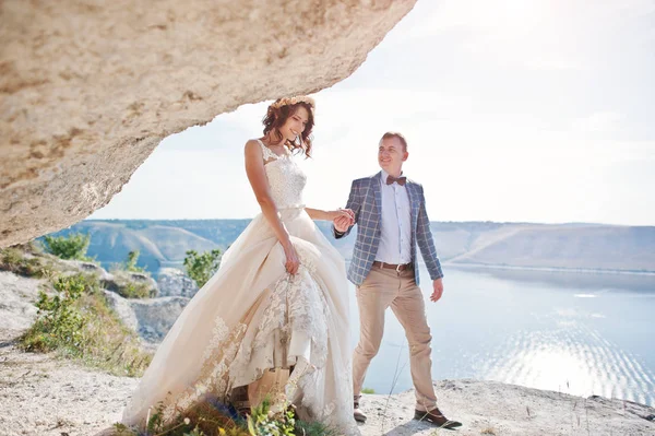 Hermosa pareja de boda posando junto a la cueva con breathtakin —  Fotos de Stock