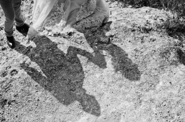 Düğün gölge siluetleri bir kayanın üzerinde kaç. Siyah ve 