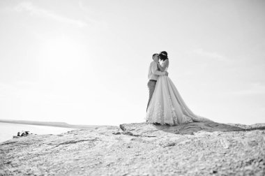 Harika gelin ve yakışıklı damat öpüşme ve üzerinde clif sarılma