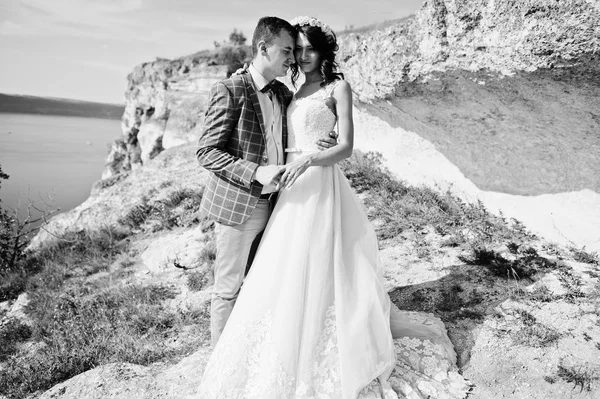 Hermosa pareja de boda posando junto a la cueva con breathtakin —  Fotos de Stock