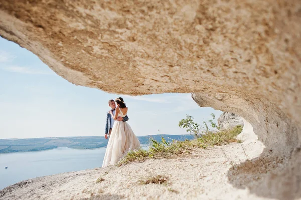 Casal lindo posando ao lado da caverna com tirar o fôlego — Fotografia de Stock