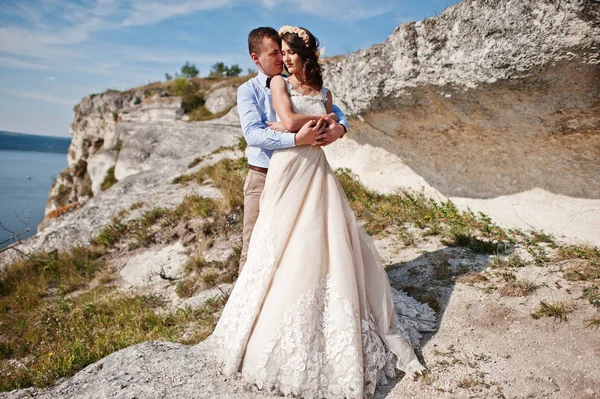 Gorgeous wedding couple posing next to the cave with breathtakin — Stock Photo, Image
