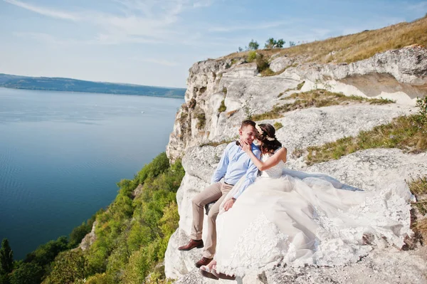 Impressionante jovem casal de casamento sentado na beira do penhasco w — Fotografia de Stock