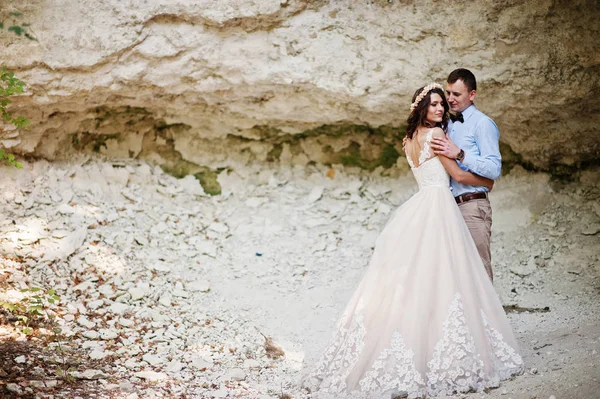 Hermosa novia con novio guapo posando al lado de la cueva en f — Foto de Stock