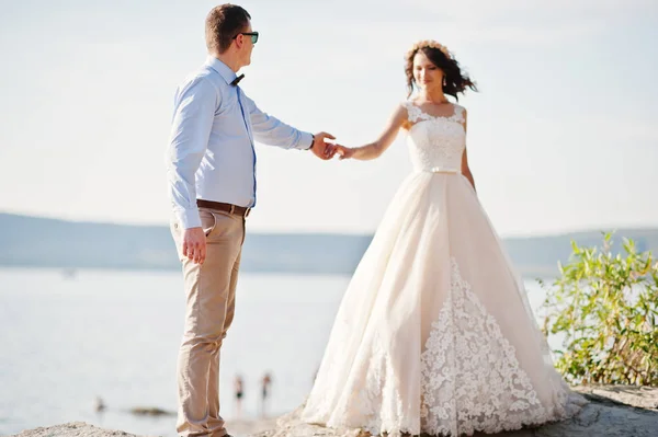 Couple nouvellement marié dansant sur la falaise rocheuse avec vue sur un — Photo