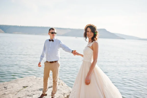 Fantástica pareja de boda de pie en el borde del precipicio rocoso —  Fotos de Stock