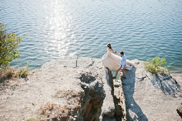 Pareja de recién casados bailando en el acantilado rocoso con vistas a un —  Fotos de Stock