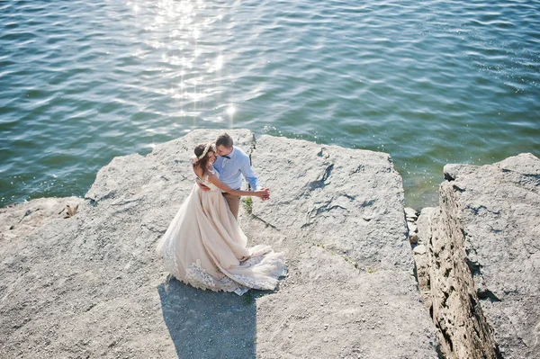 Nygifta par dansar på en klippa med utsikt över en — Stockfoto