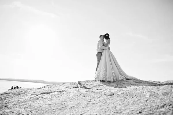 Úžasné nevěsta a pohledný ženich líbání a objímání clif — Stock fotografie