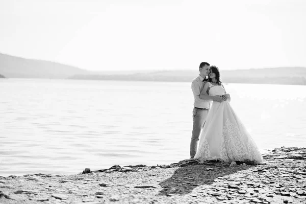 Fantastisk ung par hålla händerna på sjöstranden på deras su — Stockfoto