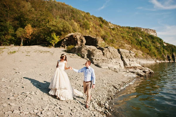 Increíble joven pareja cogida de la mano en la orilla del lago en su su su —  Fotos de Stock