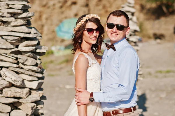 Splendida coppia di nozze in piedi accanto alla pila di pietre su t — Foto Stock
