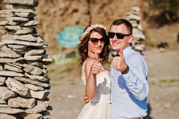 Gorgeous wedding couple standing next to the pile of stones on t — Stock Photo, Image