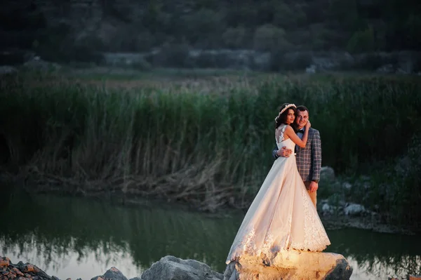 Prachtige bruiloft paar bedrijf handen en kijken naar elkaar — Stockfoto