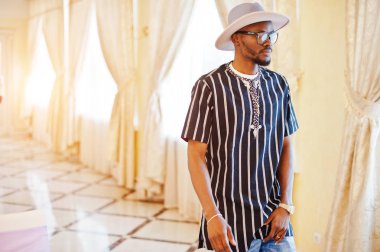 Yakışıklı zenci çizgili gömlek, şapka ve gözlük yürüyüş 