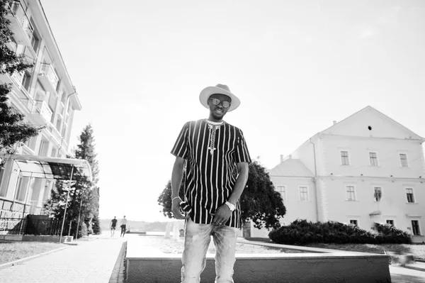 Ελκυστική αφρικανική αμερικανική άνθρωπος σε ριγέ πουκάμισο, καπέλο και sungla — Φωτογραφία Αρχείου