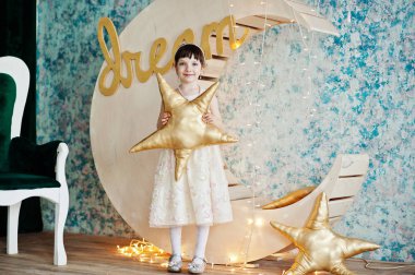 Ahşap ay deco yanında poz elbiseli güzel küçük kız