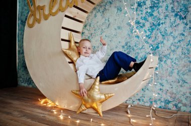 Sevimli küçük yakışıklı çocuk yapay ay dekorasyon WHI üzerinde poz