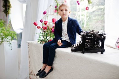 Şık bir portresi ve hndsome rüzgarla oturan küçük çocuk