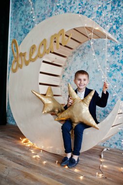 Sevimli küçük yakışıklı çocuk yapay ay dekorasyon WHI üzerinde poz