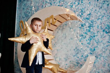 Sevimli küçük yakışıklı çocuk yapay ay dekorasyon WHI üzerinde poz