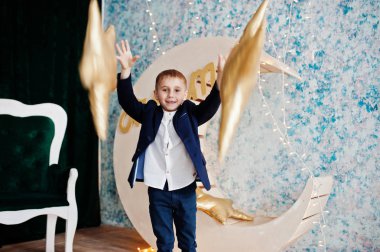 Sevimli küçük yakışıklı çocuk yapay ay dekorasyon WHI üzerinde poz