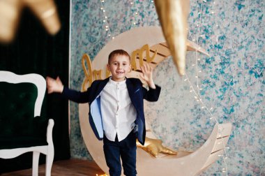 Sevimli küçük yakışıklı çocuk yapay ay dekorasyon WHI üzerinde poz