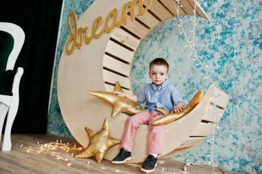 Sevimli küçük yakışıklı çocuk yapay ay dekorasyon WHI üzerinde poz