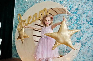 Ahşap ay deco yanında poz elbiseli güzel küçük kız