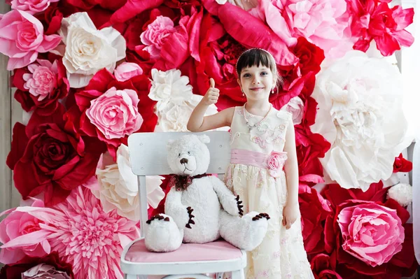 Маленькая милая девочка позирует в платье с белым плюшевым медвежонком Ага — стоковое фото