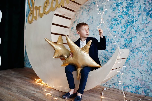 Sevimli küçük yakışıklı çocuk yapay ay dekorasyon WHI üzerinde poz