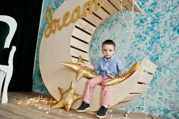 Lindo pequeño guapo chico posando en artificial luna decoración whi — Foto de Stock