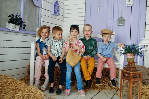 Preschool kids posing outside the house with straw in the rural