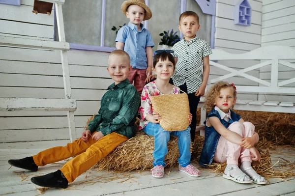 Preschool kids posing outside the house with straw in the rural