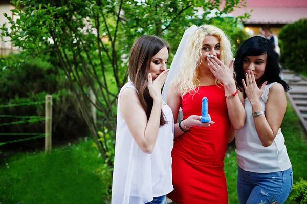 Beautiful bride in red dress showing a soap in penis shape to he — Stockfoto