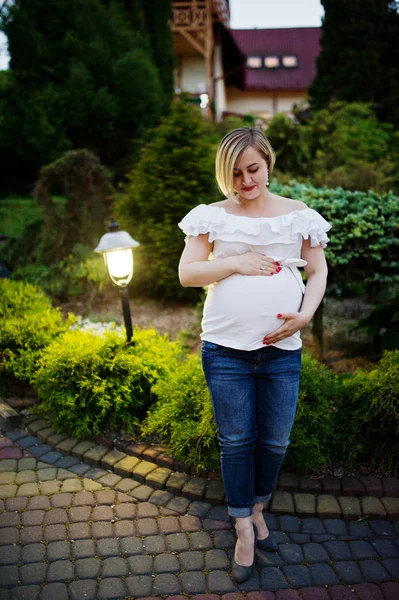 Fabuleux demoiselle d'honneur enceinte portant un jean et un t-shirt blanc pos — Photo