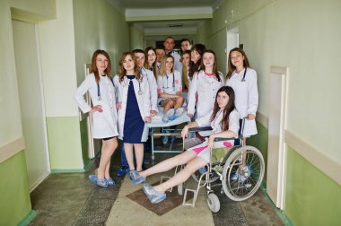 Çılgın genç doktorlar tekerlekli sandalyede poz tarafından eğleniyor 