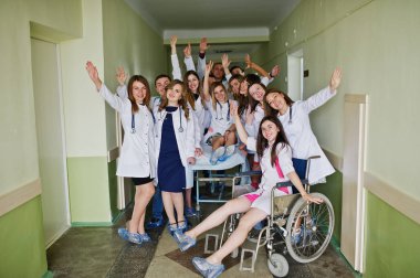 Çılgın genç doktorlar tekerlekli sandalyede poz tarafından eğleniyor 