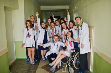 Çılgın genç doktorlar tekerlekli sandalyede poz tarafından eğleniyor 
